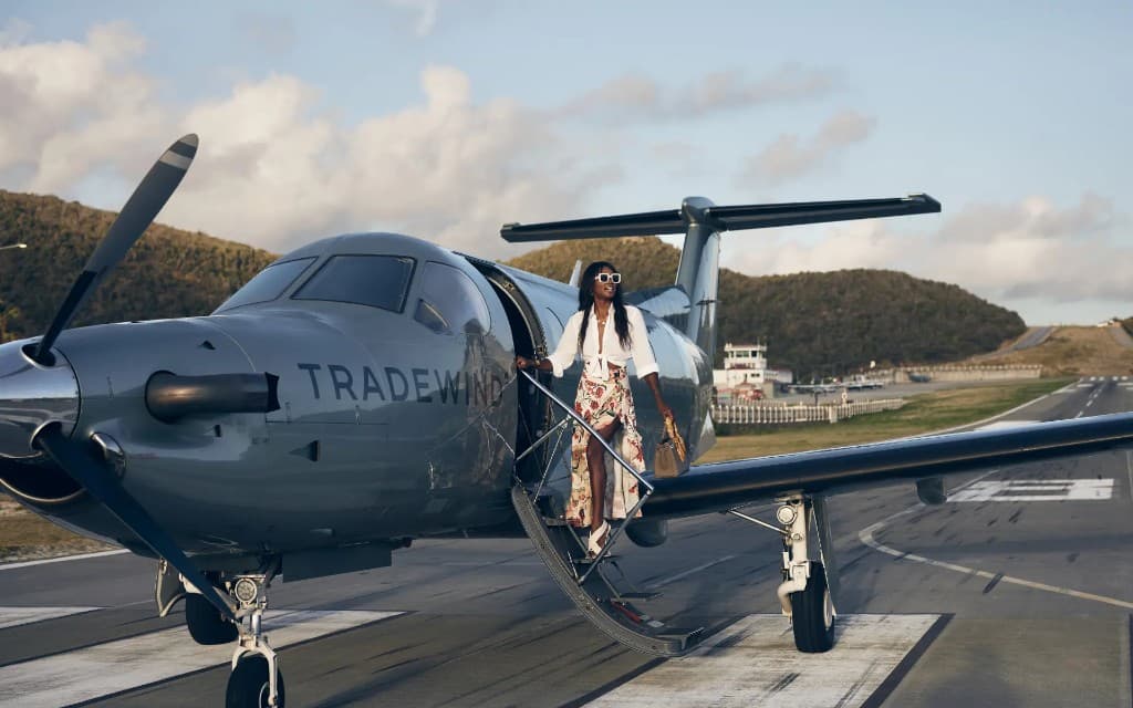 Guest disembarking a Tradewind turboprop on a tropical runway, private flight arrival